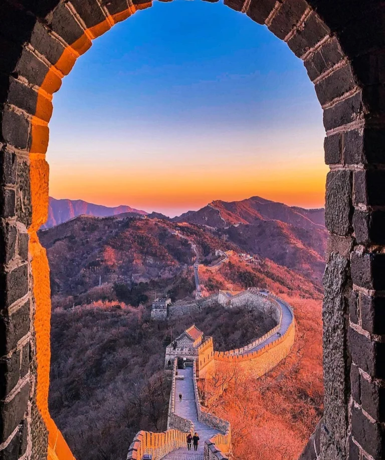 Coucher de soleil sur les montagnes vu à travers une fenêtre de tour de guet de la Grande Muraille