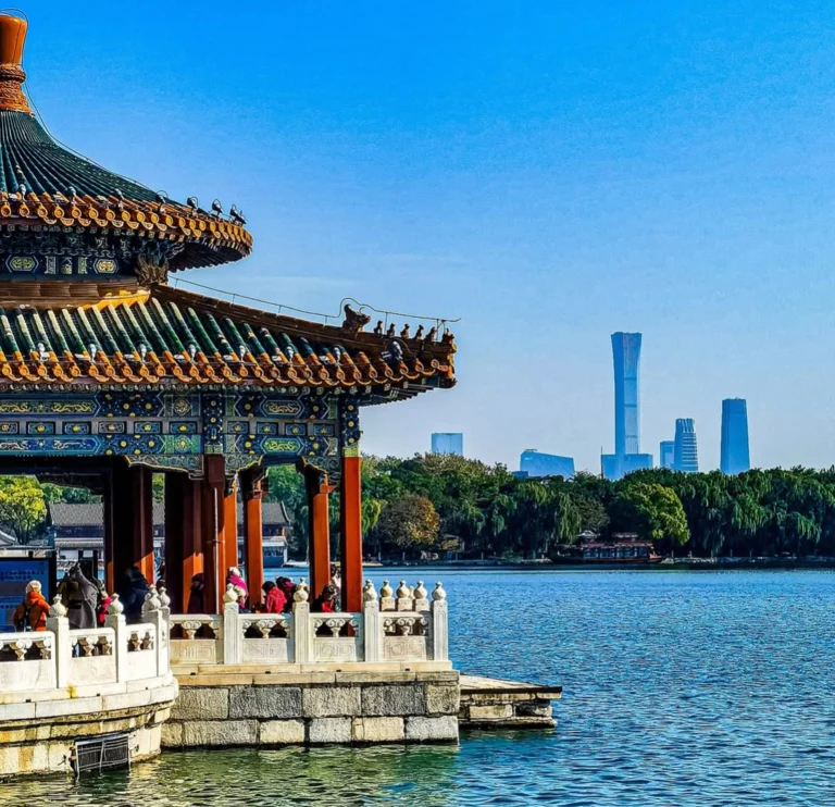 Pavillon au bord du lac Beihai avec les gratte-ciel de Pékin à l'horizon