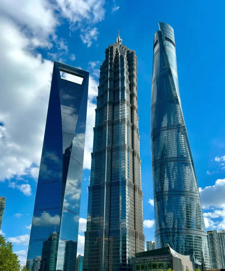 Tour Jin Mao entre la Shanghai Tower et le World Financial Center sous un ciel bleu