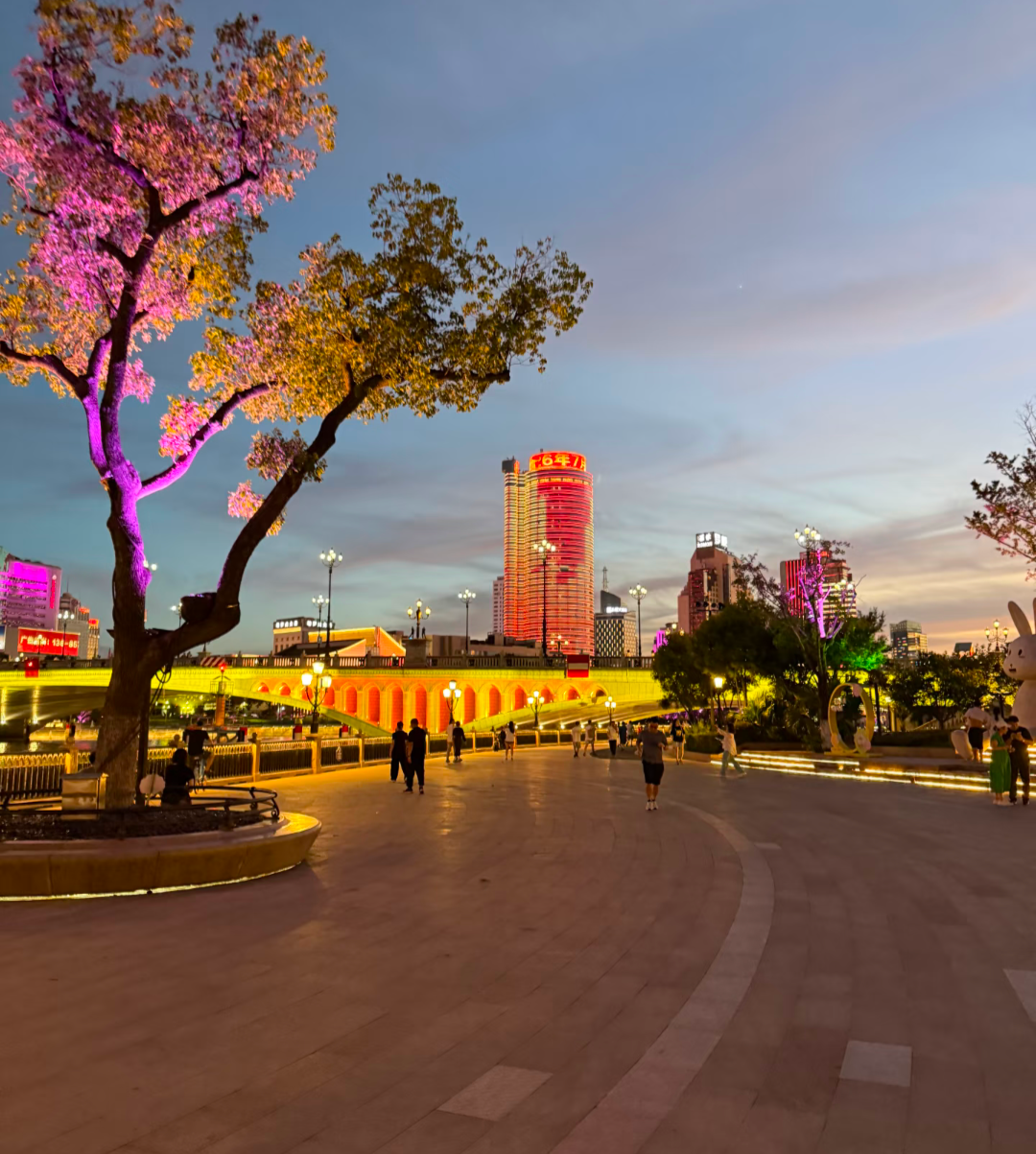 Place animée du centre de Ningbo illuminée à la tombée de la nuit