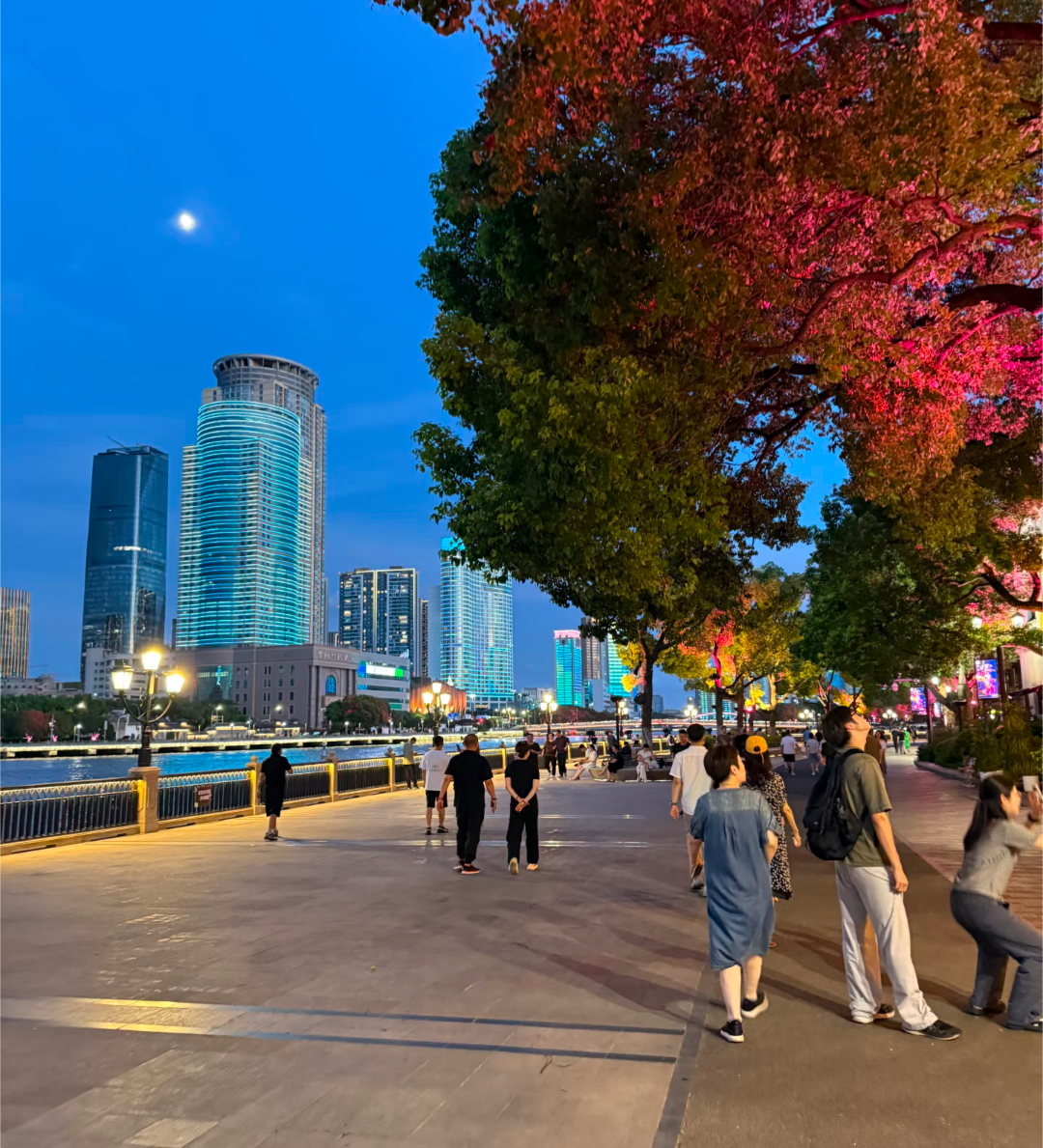 Promenade au bord de la rivière à Ningbo la nuit, gratte-ciels illuminés et arbres d'automne